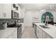 White kitchen with gray backsplash and stainless steel appliances at 17827 Althea Blue Pl, Lutz, FL 33558