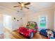 A bedroom features hardwood flooring, a ceiling fan, and Jeep-themed decor and bedding at 37439 Meridian Ave, Dade City, FL 33525