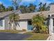 Inviting townhome featuring palm trees, a blue front door with wreath, and well-maintained landscaping at 381 Estero Ct, Safety Harbor, FL 34695
