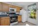 Bright kitchen with wood cabinets, white appliances, and a window at 381 Estero Ct, Safety Harbor, FL 34695