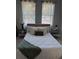 Inviting bedroom with decorative pillows, stylish side tables, lamps, and two windows with sheer curtains at 4202 N 15Th St, Tampa, FL 33610