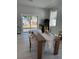 Sunlit dining room with a rustic table, modern chairs, and sliding glass doors to the backyard at 4202 N 15Th St, Tampa, FL 33610