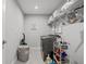 Bright laundry room with washer, storage shelves, and a laundry cart at 5805 Grand Sonata Ave, Lutz, FL 33558