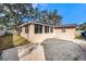 Tan colored studio, with large windows and a spacious yard at 5857 25Th S St, St Petersburg, FL 33712