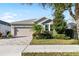 Single-story home with a two-car garage and landscaped front yard at 6033 Plover Meadow St, Lithia, FL 33547