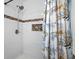 Updated shower with white tile and a floral shower curtain at 6086 46Th N Ave, Kenneth City, FL 33709