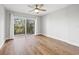 Bright bedroom featuring hardwood floors and sliding glass doors to balcony at 125 Mariner Dr # 125, Tarpon Springs, FL 34689