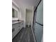 Modern bathroom with a double vanity, granite countertop, and frameless shower at 1302 E Annie St, Tampa, FL 33612