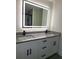 Modern bathroom with a double vanity, granite countertop, and large illuminated mirror at 1302 E Annie St, Tampa, FL 33612