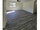Spacious living room featuring grey vinyl flooring and large window at 1302 E Annie St, Tampa, FL 33612