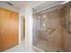 Bathroom featuring tiled walk-in shower with safety bar, glass door, and neutral decor at 1388 S Hercules Ave, Clearwater, FL 33764