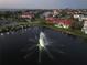 Aerial view of a lake with a fountain in a neighborhood with homes and water access at 1414 Alhambra Dr, Apollo Beach, FL 33572