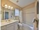 Hall bathroom featuring a shower-tub combo, single sink vanity and neutral finishes at 1414 Alhambra Dr, Apollo Beach, FL 33572