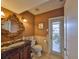 Half-bathroom with decorative mirror, granite countertop vanity, and direct access to the outdoor area at 1414 Alhambra Dr, Apollo Beach, FL 33572