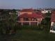 Aerial view of the back of a home with a screened-in pool and lush landscaping at 1414 Alhambra Dr, Apollo Beach, FL 33572