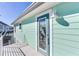 Private entrance with a unique glass door design and teal colored building at 17410 1St E St, Redington Shores, FL 33708