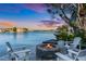 Relaxing waterfront patio with fire pit and seating area at 17410 1St E St, Redington Shores, FL 33708