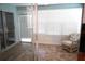 Relaxing sunroom with tiled floor and wicker chair at 409 Bloom Ct # 2B, Sun City Center, FL 33573