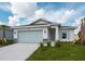 Single story home with light green garage door and neatly landscaped lawn at 475 Winwood Ct, Port Charlotte, FL 33954