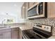 Stainless steel appliances and gray cabinets in modern kitchen at 475 Winwood Ct, Port Charlotte, FL 33954