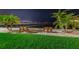 Night view of waterfront with benches, palm trees, and calm water at 622 Edgewater Dr # 523, Dunedin, FL 34698