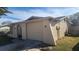 Tan house with a single car garage and side yard at 7234 Rockwood Dr, Port Richey, FL 34668