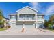 Two-story house with three-car garage, balcony, and landscaping at 8423 Blue Rock Dr, New Port Richey, FL 34653