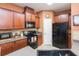 Modern kitchen with dark wood cabinets, black appliances, and ample counter space at 8423 Blue Rock Dr, New Port Richey, FL 34653