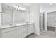 Spacious bathroom features double sinks, large mirror, and walk-in glass shower at 10320 Cross River Trl, Parrish, FL 34219