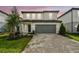 Beautiful home exterior features a manicured lawn, charming landscaping, and a brick paver driveway at 10328 Cross River Trl, Parrish, FL 34219