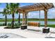 Wooden pergola with a swing overlooking a lake at 10328 Cross River Trl, Parrish, FL 34219