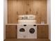 Functional laundry room with washer, dryer, and wood cabinets at 13750 Park Blvd # 1, Seminole, FL 33776