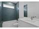 Bathroom with blue tile, white vanity, and a bathtub at 13750 Park Blvd # 4, Seminole, FL 33776