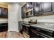 Modern kitchen with dark cabinetry, granite countertops, and stainless steel appliances at 13913 Sage Thrasher Ln, Riverview, FL 33579