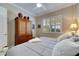 Bedroom with king-size bed and wooden armoire at 15314 Valencia Del Sol St, Wimauma, FL 33598