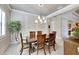 Elegant dining room with a wood table and six chairs, featuring a beautiful chandelier at 15314 Valencia Del Sol St, Wimauma, FL 33598