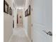 Bright hallway with neutral walls and tile flooring, leading to bedrooms at 15314 Valencia Del Sol St, Wimauma, FL 33598