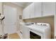 Bright laundry room with storage and door at 15314 Valencia Del Sol St, Wimauma, FL 33598