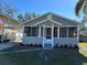 Gray house with screened porch, carport, and landscaped yard at 1902 W Cluster Ave, Tampa, FL 33604