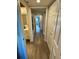 Long hallway with light wood-look floors and access to bedrooms and bath at 2021 Shangrila Dr # 60, Clearwater, FL 33763