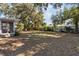 Large grassy backyard with mature trees and screened porch at 2085 Georgianna St, Largo, FL 33774