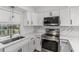 Modern kitchen with white cabinets, stainless steel appliances and quartz countertops at 2085 Georgianna St, Largo, FL 33774