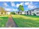 Pathway through grassy area, residential buildings in background at 2400 Winding Creek Blvd # 24-203, Clearwater, FL 33761