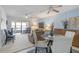 Bright dining area with glass table and seating for four, open to living room at 2400 Winding Creek Blvd # 24-203, Clearwater, FL 33761