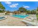 Community swimming pool area with sun loungers and hot tub under a sunny, partly cloudy sky at 2400 Winding Creek Blvd # 24-203, Clearwater, FL 33761