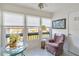 Bright sunroom with glass table, comfy chair, and view of the outdoors at 2400 Winding Creek Blvd # 24-203, Clearwater, FL 33761