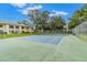 Well-maintained tennis court with green surface and surrounding trees at 2400 Winding Creek Blvd # 24-203, Clearwater, FL 33761