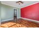 Bedroom with wood floors, ceiling fan, and bold red accent wall at 3306 N Howard Ave, Tampa, FL 33607