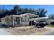 Front view of a manufactured home with carport, landscaping, and golf cart at 4927 Britni Way, Zephyrhills, FL 33541