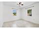 Simple bedroom with ceiling fan, window, and speckled flooring at 6500 7Th S Way, St Petersburg, FL 33705